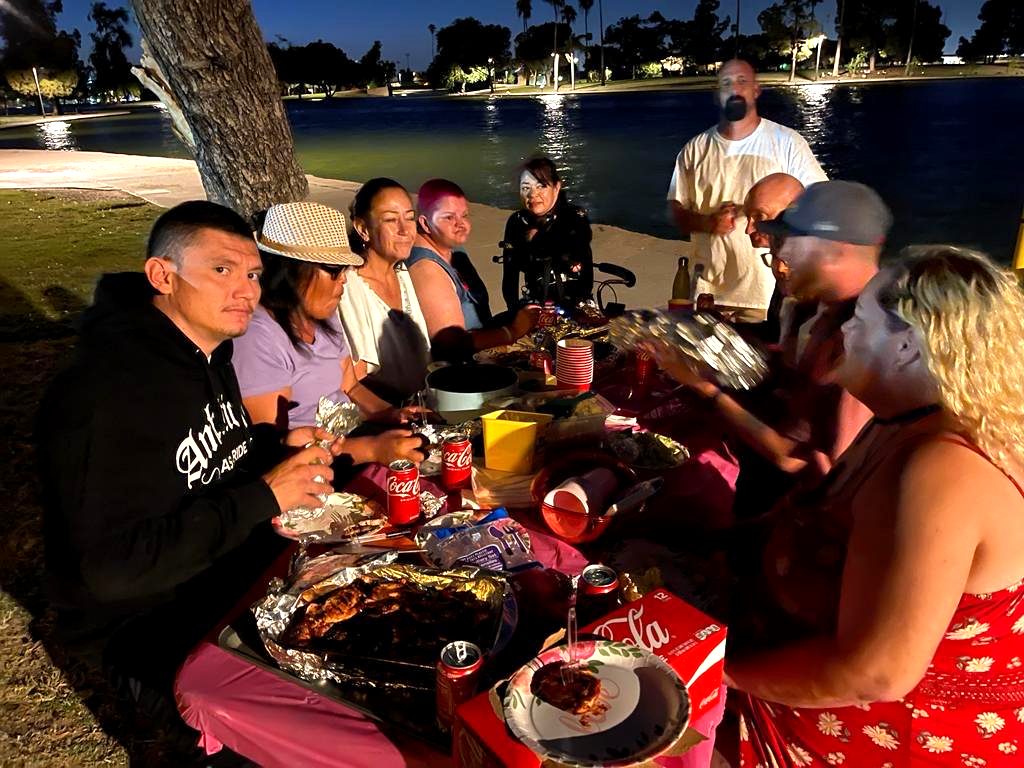 Neighbors sharing a community dinner outdoors in the evening