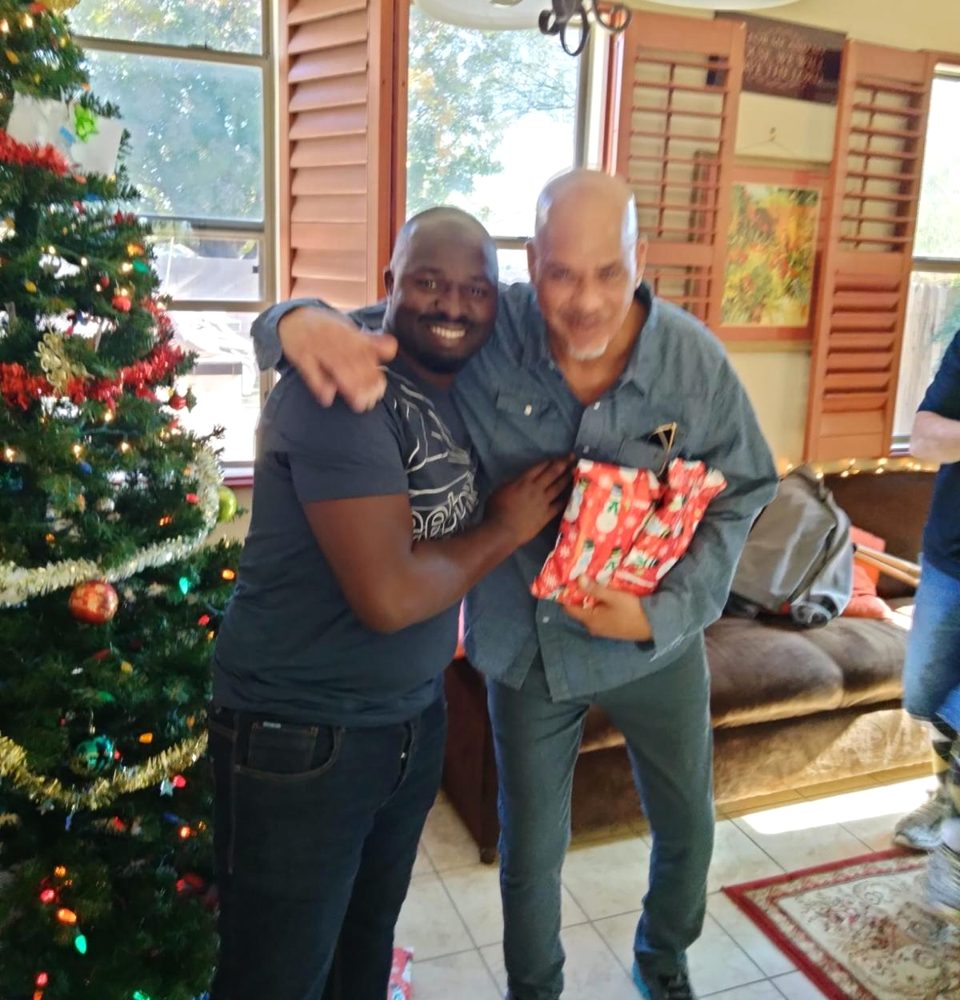 A volunteer sharing holiday gifts and a hug